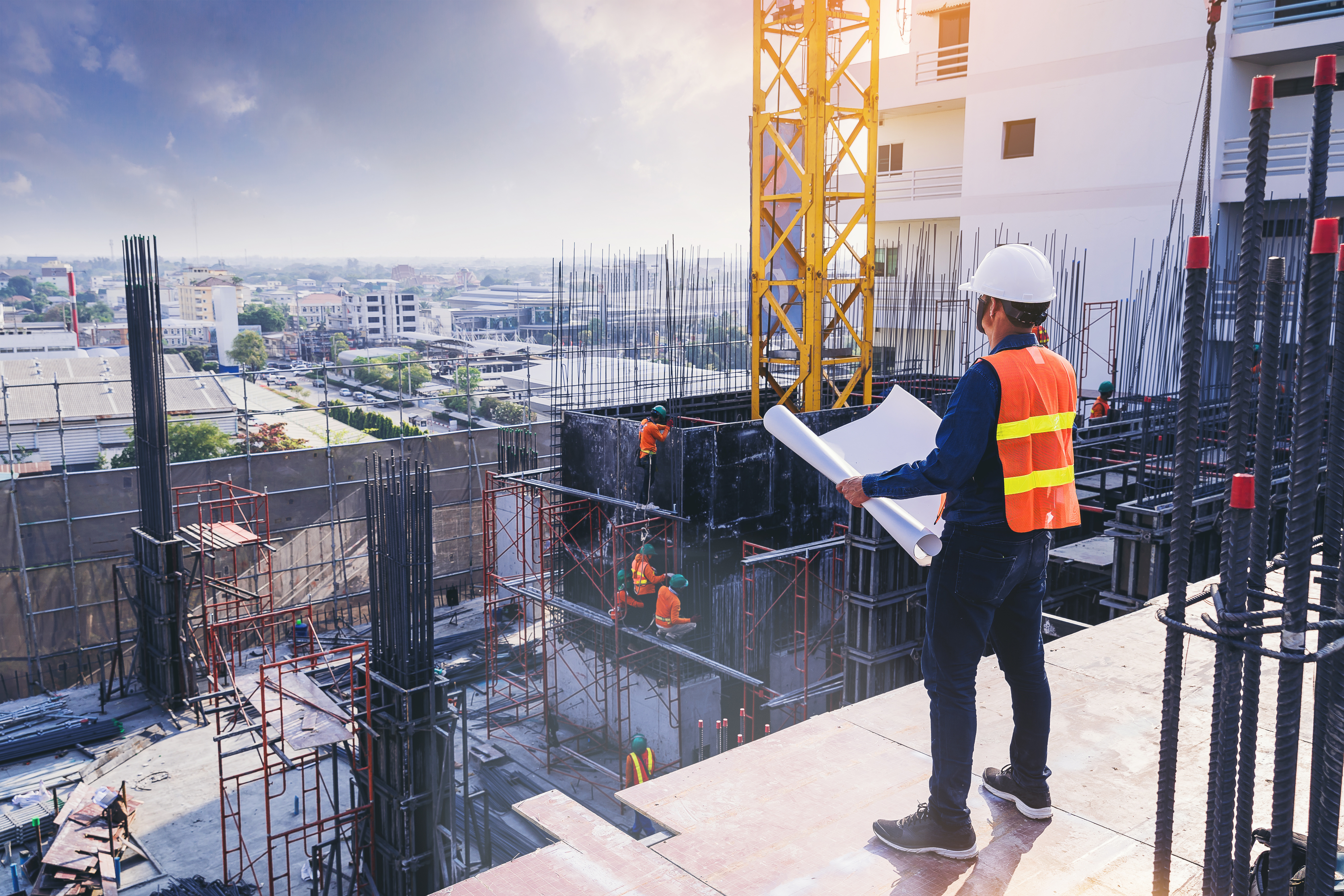 Smart civil architect engineer inspecting and working outdoors building side with blueprints. engineering and architecture concept.
