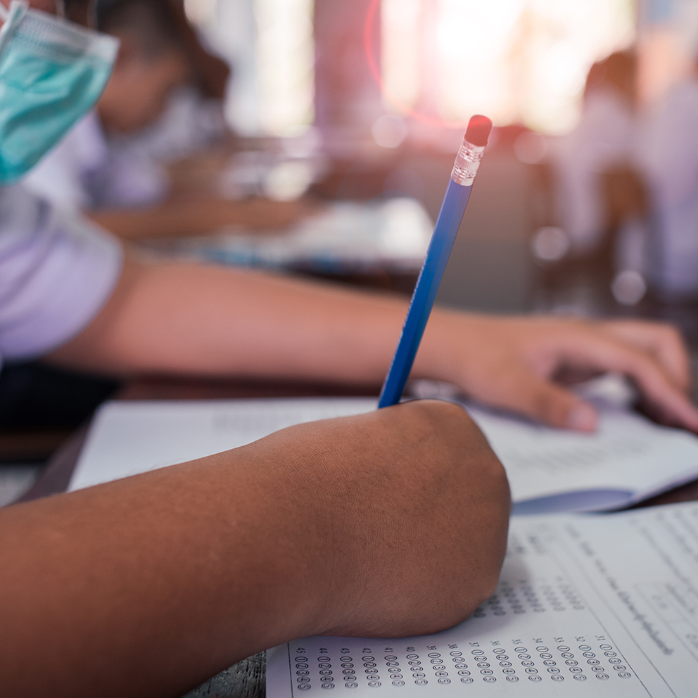 Students wearing mask for protect corona virus or covid-19 and doing exam in classroom with stress.